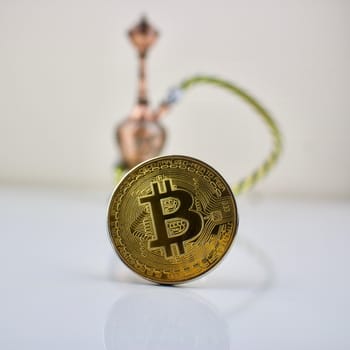 Cryptocurrency physical gold bitcoin coin and small sisha.