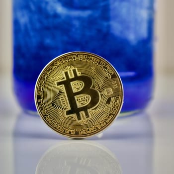 Cryptocurrency physical gold bitcoin coin on blue pattern