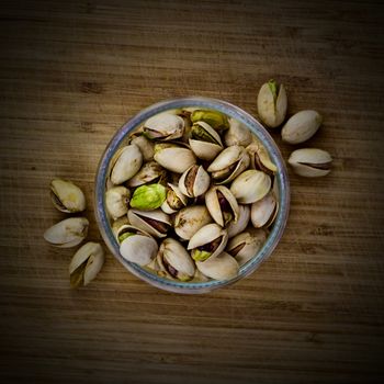 Pistachios nuts glass concept on old wooden board