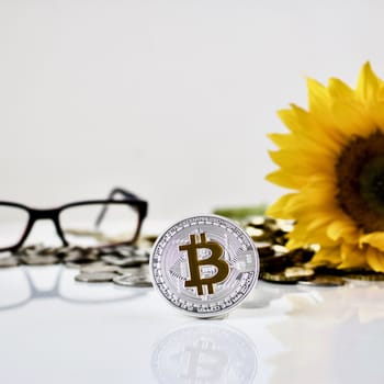 Cryptocurrency physical silver bitcoin coin with sunflower and red glasses