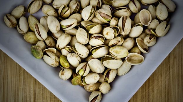 Pistachios on square white plate
