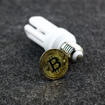 Cryptocurrency gold bitcoin coin with a white eco bulb