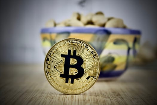 Cryptocurrency physcial gold bitcoin coin pistachios concept. Black sign.