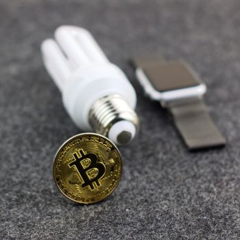 Cryptocurrency physical gold bitcoin coin white eco bulb and smartwatch