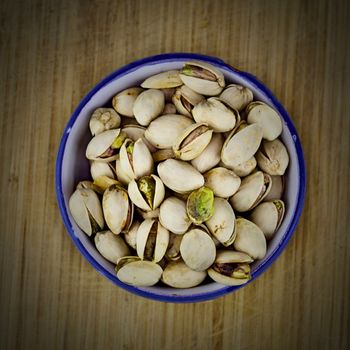 Tasty pistachios on the wooden board.