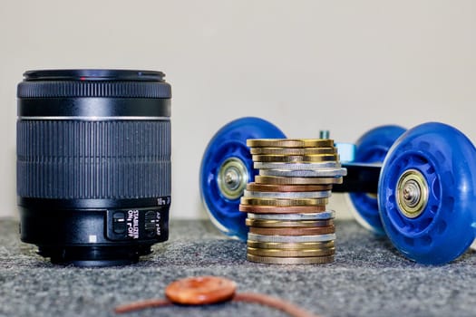 Black dslr camera lens, camera trolley and coins money.