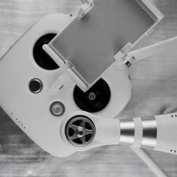 White drone arm near white aircraft hand controller.