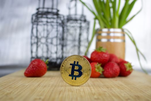 Cryptocurrency physical gold bitcoin coin strawberry concept.