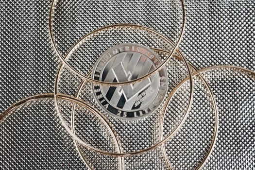 Cryptocurrency physical silver Litecoin coin under gold rings