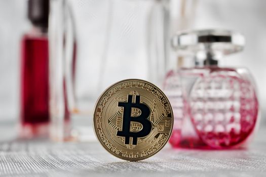 Digital currency physical gold bitcoin coin - pink perfume composition.