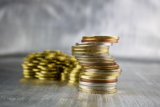 Money concept. Big tower coins on the silver background.