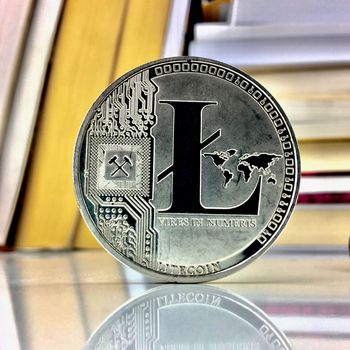 Cryptocurrency silver litecoin coin near books