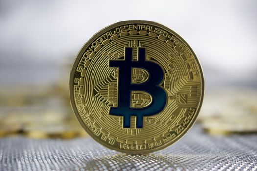 Cryptocurrency physical gold bitcoin coin with a blue sign.
