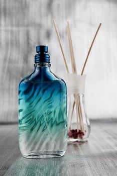 Fragrance composition. Blue perfume bottle on the table