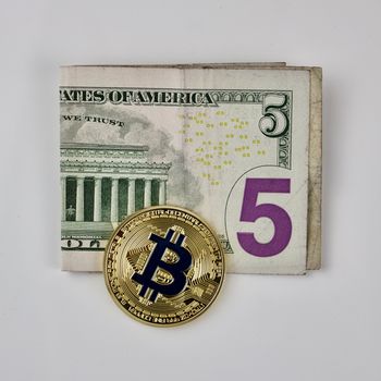 Cryptocurrency physical gold bitcoin coin on the five dollars.