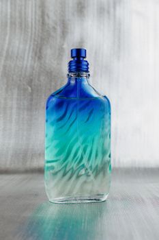 Blue and green fragrance big bottle and silver background.