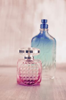 Small pink bottle near big green fragrance bottle