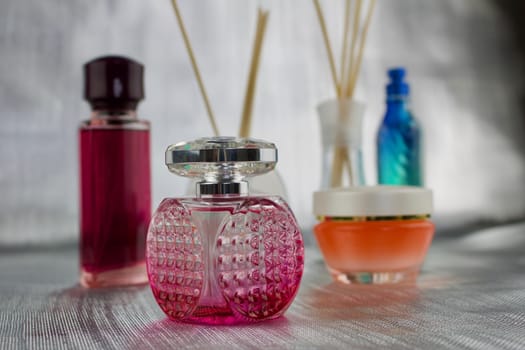 Fragrance in pink bottles on the table near orange creme.