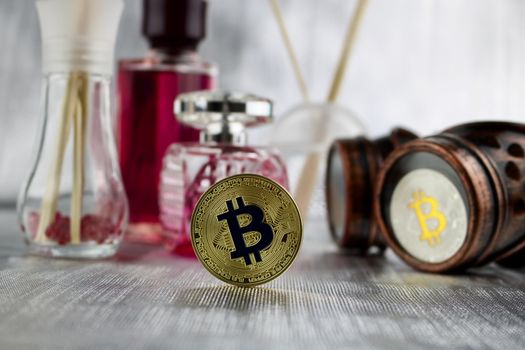 Cryptocurrency physical gold bitcoin coin, steampunk glasses and pink perfumes.