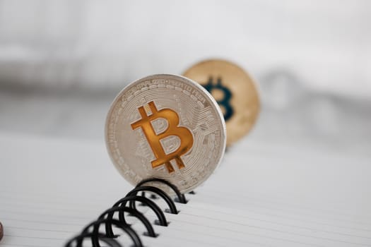 Cryptocurrency physical silver bitcoin coin near gold bitcoin.