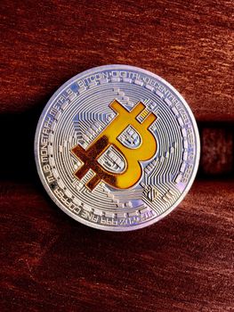 Cryptocurrency silver bitcoin coin on the red wood