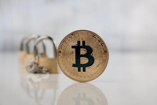 Cryptocurrency physical gold bitcoin coin near padlocks. Secure payments.
