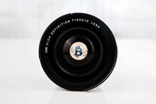Cryptocurrency physical bitcoin coin in fisheye lenses