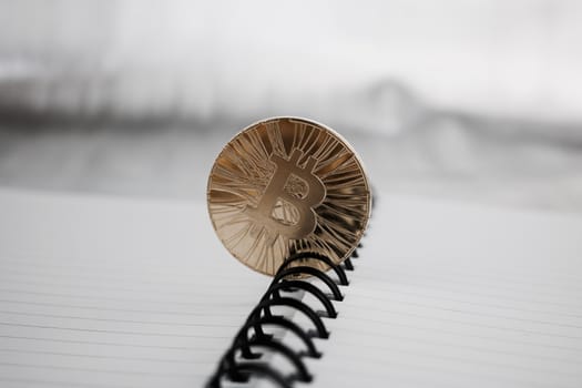 Digital currency physical gold bitcoin coin in notebook.