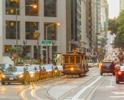 San Francisco Cable Car on focus with blurred traffic on California Street at sunset