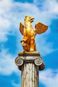 Griffin sculpture on  pedestal on the background the sky.