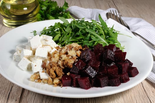 Ingredients for the preparation of salad from roasted beets, arugula, cheese feta, and walnuts.  Horizontal shot.