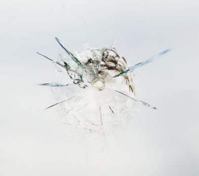 Round bullet hole in the glass with radial cracks