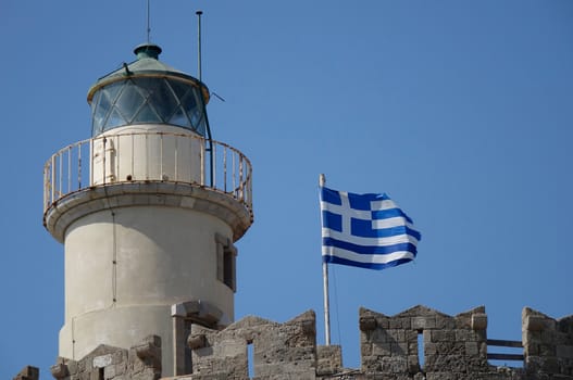 Low angle view of a lighthouse with a Greek flag