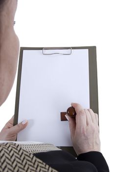 Hands with a sheet of paper and a stamp in the clipboard