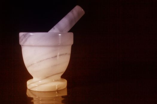 Mortar and pestle of marble on a black background