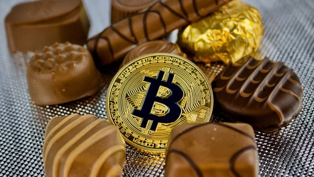 Digital currency physical gold bitcoin coin with chocolates.