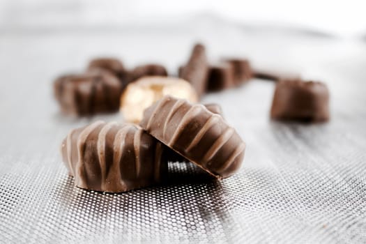 Delicious sweets in dark chocolate. Silver background concept.
