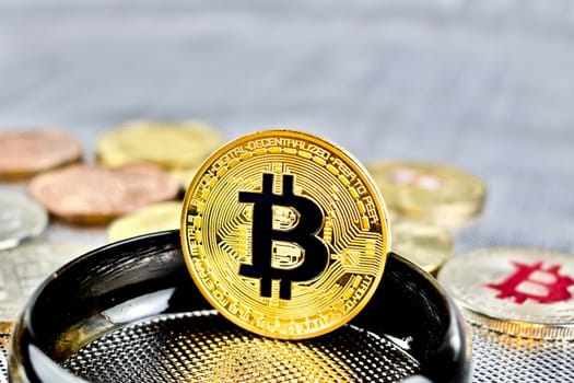Cryptocurrency physical gold bitcoin coin on black ring.