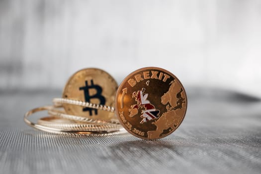 Cryptocurrency physical bitcoin coin and gold brexit coin. Europe leaving.