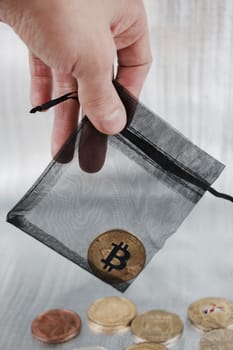Digital currency physical gold bitcoin coin in black bag.