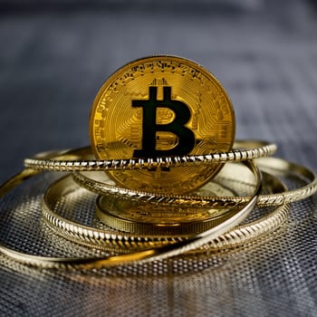 Digital currency physical gold bitcoin coin with a black sign. Gold money concept.