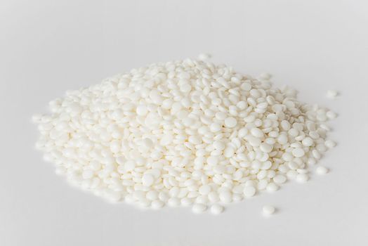 Heap of fine white thermoplastic granules on the white background