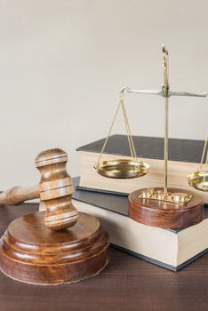 Symbols of law: wood gavel, soundblock, scales and two thick old books