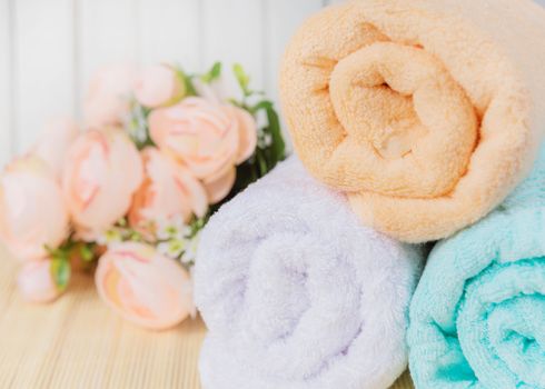 Spa concept: bath towels and bouquet of pink flowers