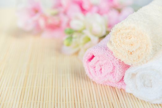 Spa concept: bath towels and bouquet of pink flowers