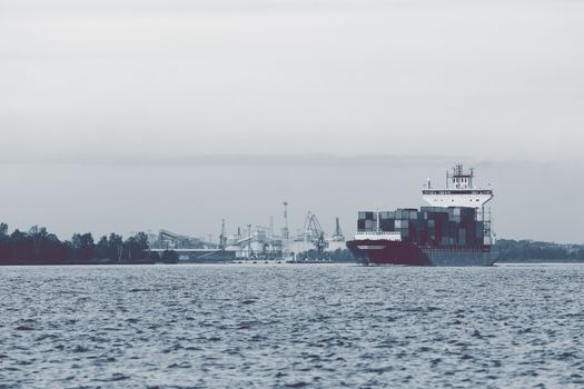 Full container ship moving to Baltic sea. Riga, Latvia