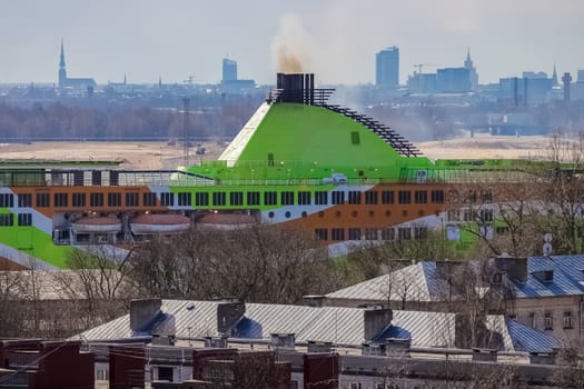 Green cruise liner. Passenger ferry sailing past the Riga city
