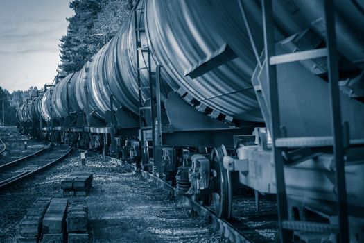 Tank wagons with oil. Freight train in forest