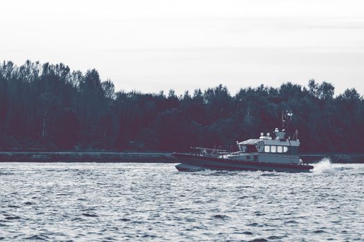 Small pilot ship sailing on the Daugava river