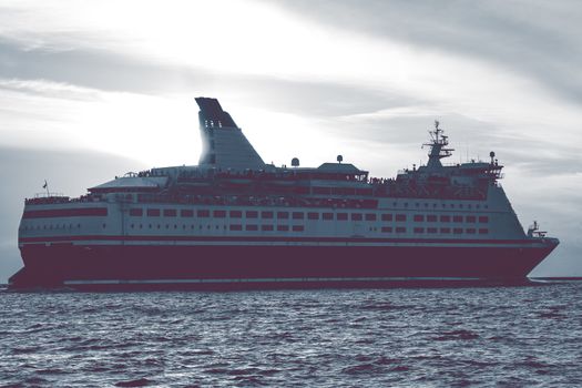 Cruise liner leaving Riga. Passenger ferry sailing at hot sunset